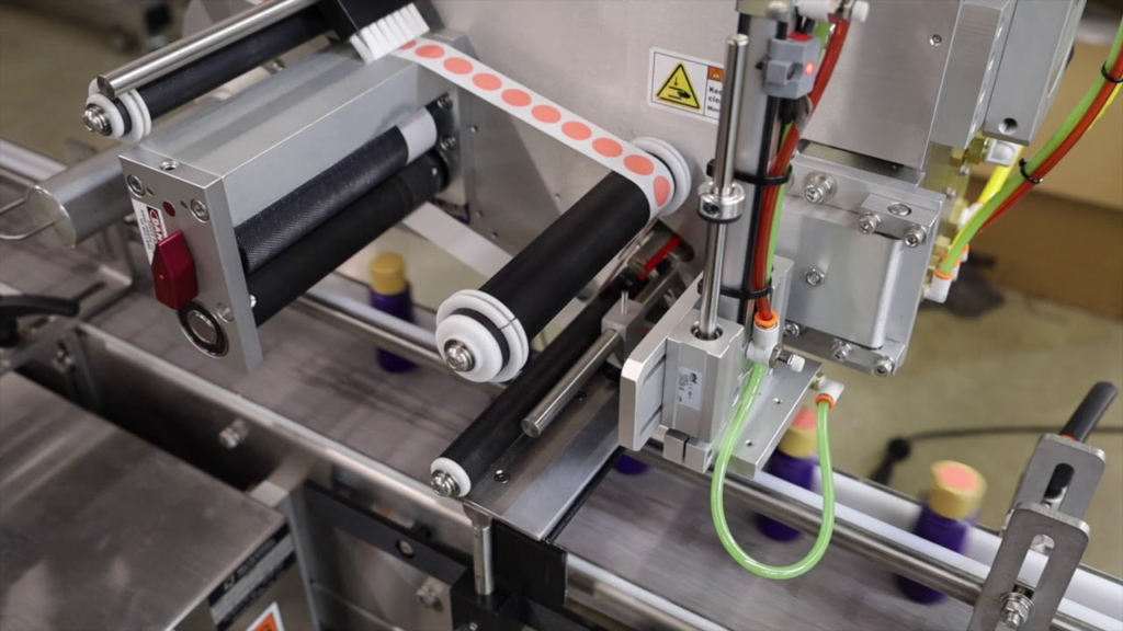 A state-of-the-art labeling applications machine efficiently applying labels to a series of products on a production line.